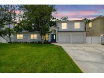 Two-story home boasting a well-manicured lawn, spacious driveway, and attached two-car garage at 5005 W Evelyn Dr, Tampa, FL 33609