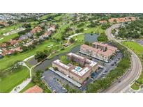 Beautiful aerial view overlooking condo buildings, parking, a lush golf course and serene lakes at 6100 Gulfport S Blvd # 415, Gulfport, FL 33707