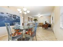 A well lit dining room features a glass top table, four upholstered chairs, and a decorative chandelier at 6100 Gulfport S Blvd # 415, Gulfport, FL 33707