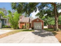 Charming single-Gathering home with a well-maintained lawn and a one-car garage on a sunny day at 9466 Forest Hills Cir, Tampa, FL 33612