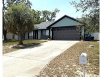 Charming single-Gathering home featuring a spacious driveway and a well-maintained front yard with mature trees at 11807 Addison St, Spring Hill, FL 34609