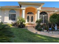 Charming home entrance with double doors, columns, arched entry and lush landscaping at 13339 Amberwood St, Hudson, FL 34669