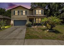 Charming two-story home featuring neutral paint, a garage, and a well-maintained front yard at 15561 Stone House Dr, Brooksville, FL 34604