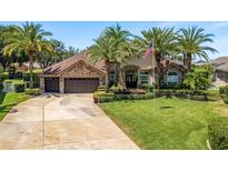 Charming home exterior with lush lawn, mature palms, stone accents, and three-car garage at 2041 Gold Dust Ct, Trinity, FL 34655