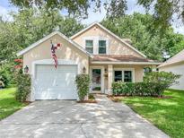 Charming single-Gathering home featuring a well-maintained lawn, attached garage, and manicured landscaping at 22443 Crows Nest Ct, Lutz, FL 33549