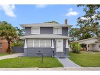 Charming two-story home featuring a gray exterior, white trim, and well-maintained front yard at 2312 Highland S St, St Petersburg, FL 33705