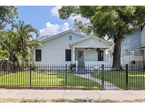 Charming bungalow with a well-manicured lawn, dark iron fence, and welcoming front porch at 2519 1St N Ave, St Petersburg, FL 33713