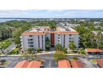 Multi-story condominium with red tile roof and covered parking nestled amongst mature, lush landscaping at 2630 Pearce Dr # 108, Clearwater, FL 33764