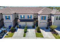 Charming townhome featuring a two-car garage and attractive landscaping at 31771 Blue Passing Loop, Wesley Chapel, FL 33545