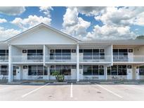 Bright exterior view of the waterfront condo building with balconies, parking, and manicured landscaping at 611 Destiny Dr # 509, Ruskin, FL 33570