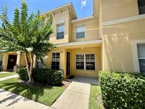 Charming two-story townhome features a sunny yellow facade with well-manicured landscaping and a welcoming front entrance at 6333 Maisie Rd, Zephyrhills, FL 33542