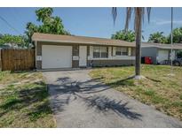 Charming single-story home featuring an attached garage and a well-manicured front yard at 6702 49Th N Ave, St Petersburg, FL 33709