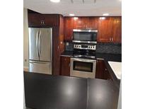 Well-equipped kitchen features stainless steel appliances and beautiful cherry wood cabinets at 7168 E Bank Dr # 7168, Tampa, FL 33617