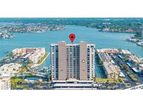 Panoramic aerial view of a waterfront condo building with pool, parking, and stunning bay views at 7300 Sun Island S Dr # 605, South Pasadena, FL 33707