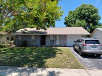 Charming single-story home featuring stone accents, well-maintained lawn, and attached one-car garage at 7317 Mitchell Ranch Rd, New Port Richey, FL 34655