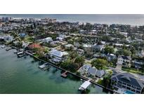 Stunning aerial view of waterfront homes with boat docks along the beach with gulf views at 761 Bay Esplanade, Clearwater Beach, FL 33767