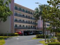 Multi-story condominium building with covered parking and nicely landscaped grounds and mature tropical trees at 8174 Terrace Garden N Dr # 204, St Petersburg, FL 33709
