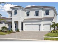 Beautiful two-story home featuring a spacious three-car garage and attractive modern architectural details at 10320 Longmeadow Ave, Parrish, FL 34219