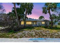 Charming single-story home surrounded by lush palm trees and a twilight sky at 123 14Th Ave, Indian Rocks Beach, FL 33785