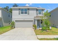 Charming two-story home with a two-car garage and well-maintained landscaping at 13765 Whiskey Daisy Dr, Dade City, FL 33525
