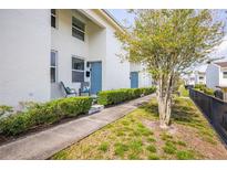 Charming townhome exterior with blue door, quaint patio seating, and fresh landscaping at 4314 La Mora Ct, Tampa, FL 33611