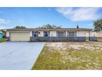 Charming single-story home with an attached garage, driveway, and an American flag displayed out front at 5250 Brody Blvd, Wimauma, FL 33598