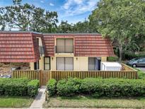 Charming two-story condo with a red tile roof and a well-maintained, enclosed front yard at 739 1St Ct, Palm Harbor, FL 34684