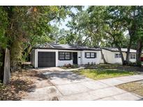 Charming single-story home boasts a black and white exterior, modern landscaping, and a well-maintained front yard at 8059 26Th N Ave, St Petersburg, FL 33710