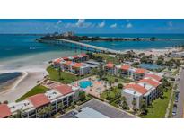 Breathtaking aerial view of beachfront condos, pool, and ocean-side bridge offering a luxurious coastal lifestyle at 865 S Gulfview Blvd # 202, Clearwater Beach, FL 33767