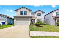 Charming two-story home with a well-maintained lawn and two-car garage at 9293 Rally Spring Loop, Wesley Chapel, FL 33545