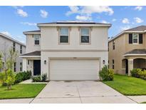 Charming two-story home with a two-car garage, manicured lawn, and welcoming curb appeal at 13686 Whiskey Daisy Dr, Dade City, FL 33525