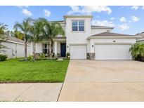 Well-manicured lawn leads up to this beautiful two-story home with a two car garage and well placed landscaping at 1675 Bering Rd, Wesley Chapel, FL 33543