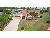 Charming home featuring a well-manicured lawn, mature palms, and a two-car garage at 202 Grayson Ct, Sun City Center, FL 33573