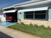 Charming home exterior with stone accents, well-maintained lawn, and a convenient carport with a red car at 250 Rosery Nw Rd # 270, Largo, FL 33770