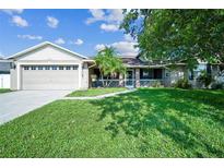 Charming home featuring a lush lawn, a screened-in porch, and an attached two-car garage at 2507 Dewberry St, Valrico, FL 33596