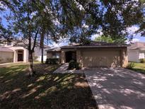 Charming single-Gathering home with a two-car garage and well-maintained lawn in a serene residential neighborhood at 2614 Queen Alberta Dr, Valrico, FL 33594
