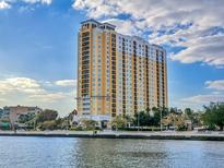 Stunning exterior shot of a luxury high-rise building with waterfront views and blue skies at 345 Bayshore Blvd # 1813, Tampa, FL 33606