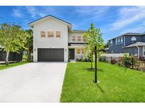 Two-story modern home featuring a well-manicured lawn and a two car garage at 3616 W Anderson Ave, Tampa, FL 33611
