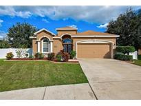 Charming one-story home with manicured lawn, flower beds, neutral paint, and a two-car garage at 6519 Twin Bridges Dr, Zephyrhills, FL 33541