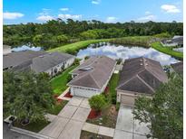 Inviting home with a picturesque pond view, surrounded by lush greenery and well-maintained landscaping at 816 College Chase Dr, Ruskin, FL 33570