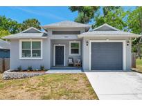 Charming single-story home featuring a gray exterior, a one-car garage, and manicured landscaping at 8608 N Arden Ave, Tampa, FL 33604