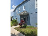 Two-story townhome with a blue exterior, covered entrance, and landscaped front yard at 13157 Kings Crossing Dr, Gibsonton, FL 33534