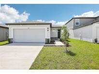 Charming single-story home featuring a two-car garage and landscaped front yard at 31647 Malbec Dr, Brooksville, FL 34602