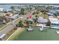 Waterfront home featuring a private dock, lush landscaping, and stunning views of the surrounding bay area at 399 161St Ave, Redington Beach, FL 33708