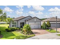 Beautiful single-story home with manicured lawn and brick driveway, exuding curb appeal at 4620 Ballast Crest Cv, Land O Lakes, FL 34638