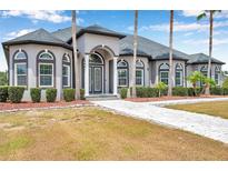 Charming home with a landscaped front yard, elegant columns, and arched windows that enhance its curb appeal at 602 Swilley Rd, Plant City, FL 33567