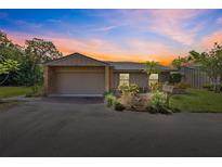 Charming single-story home with an attached garage and well-maintained landscaping at dusk at 6101 Willow Oak Cir, Bradenton, FL 34209