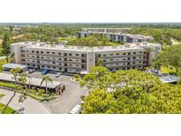 Low-angle shot of condominium building with well-maintained parking, landscaping, and views of natural areas at 6188 80Th N St # 101, St Petersburg, FL 33709