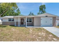 Charming single Gathering home featuring a decorative front door, garage, and inviting curb appeal at 6309 7Th Ave, New Port Richey, FL 34653