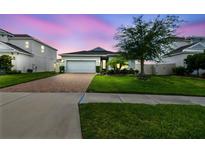 Beautiful single-Gathering home with manicured lawn, brick driveway, and attached two car garage at 751 Cajeput Loop, Tarpon Springs, FL 34689